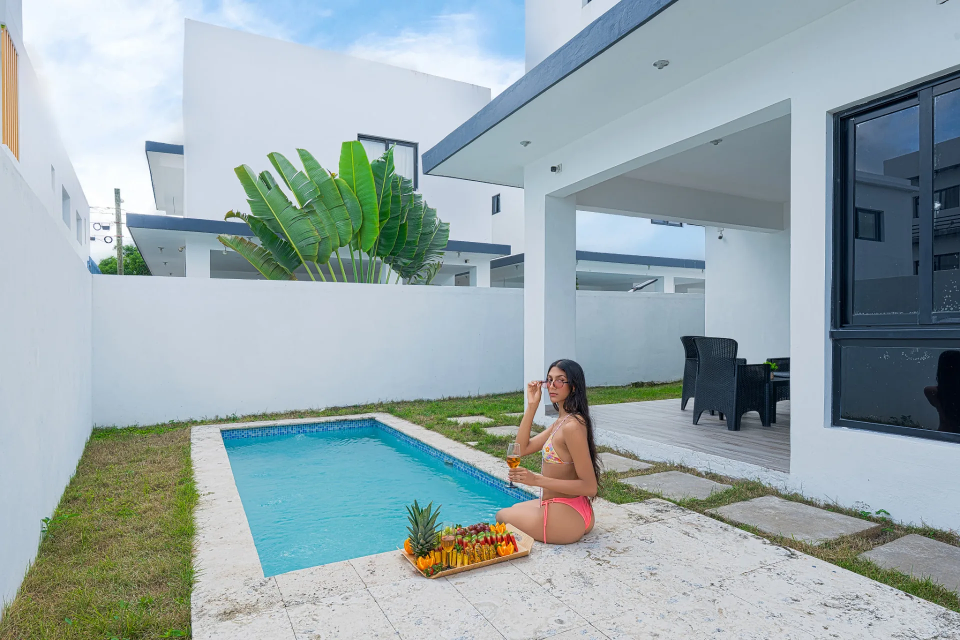Private walled courtyard with plunge pool, covered terrace and tropical planting at a modern villa