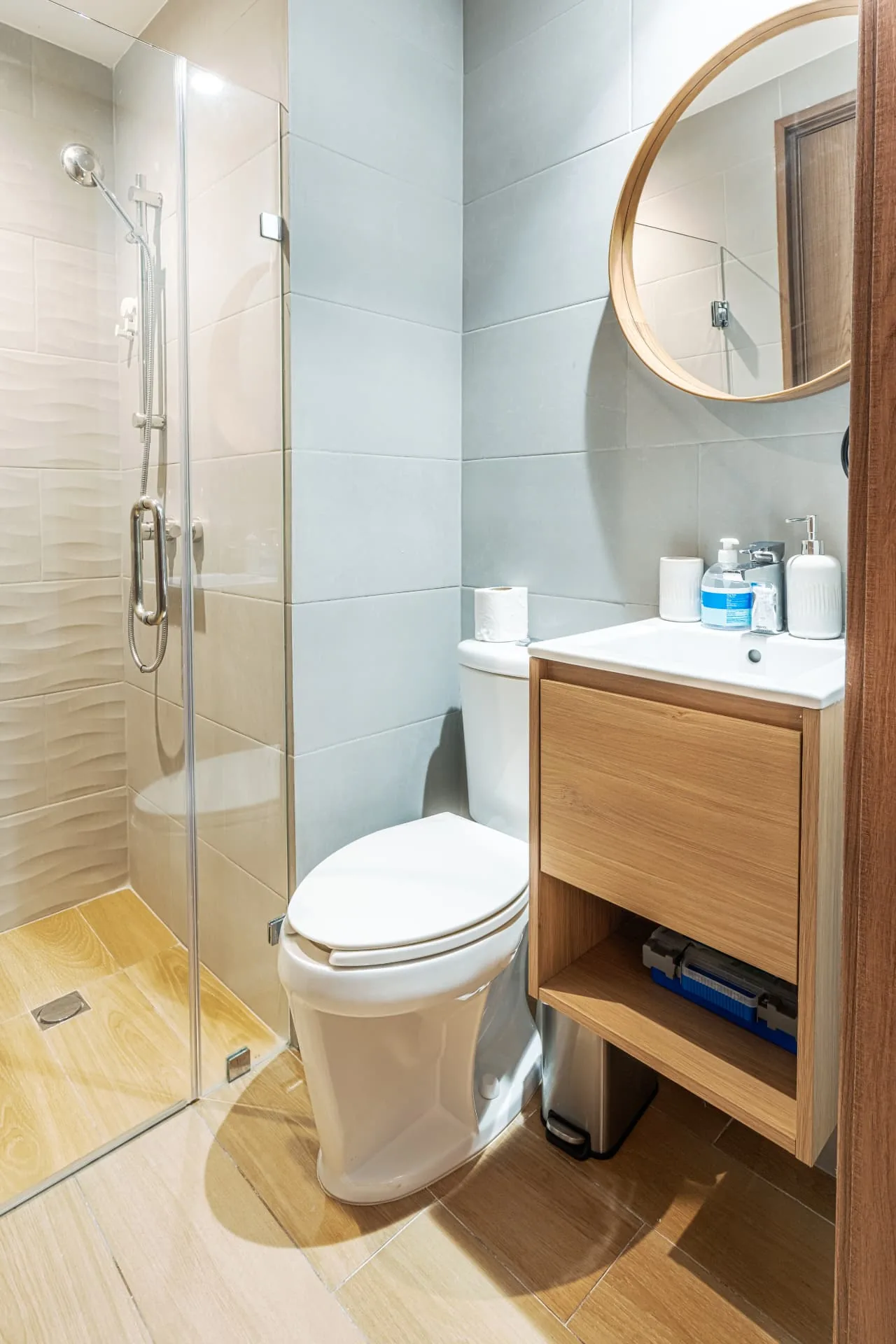 Guest bathroom with textured tile shower, round timber mirror and floating vanity