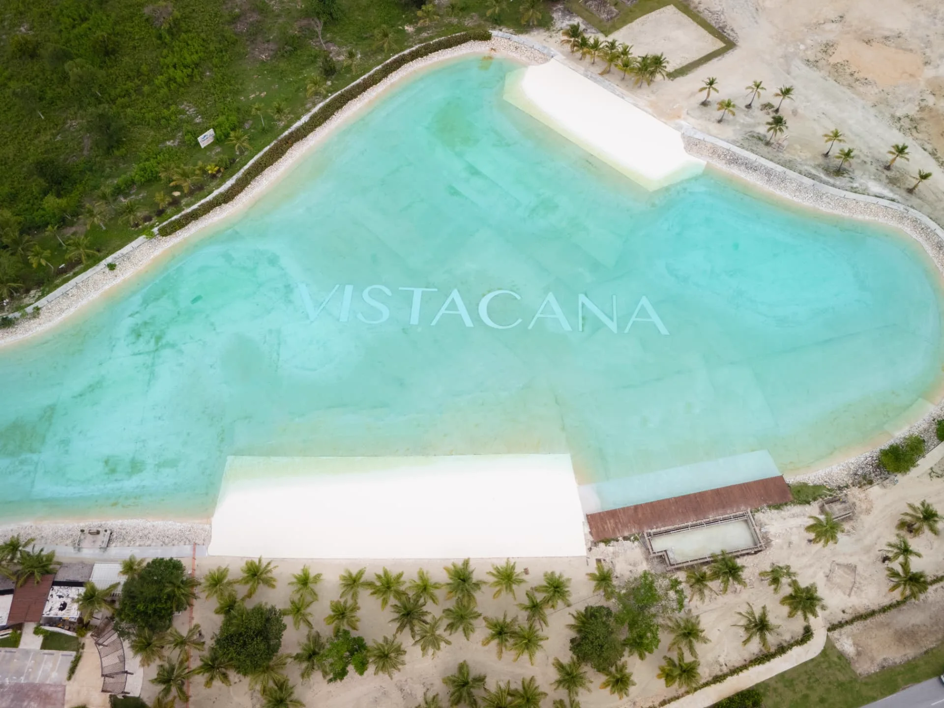 Top-down aerial of the Vista Cana crystal lagoon with white sand beaches and palm groves