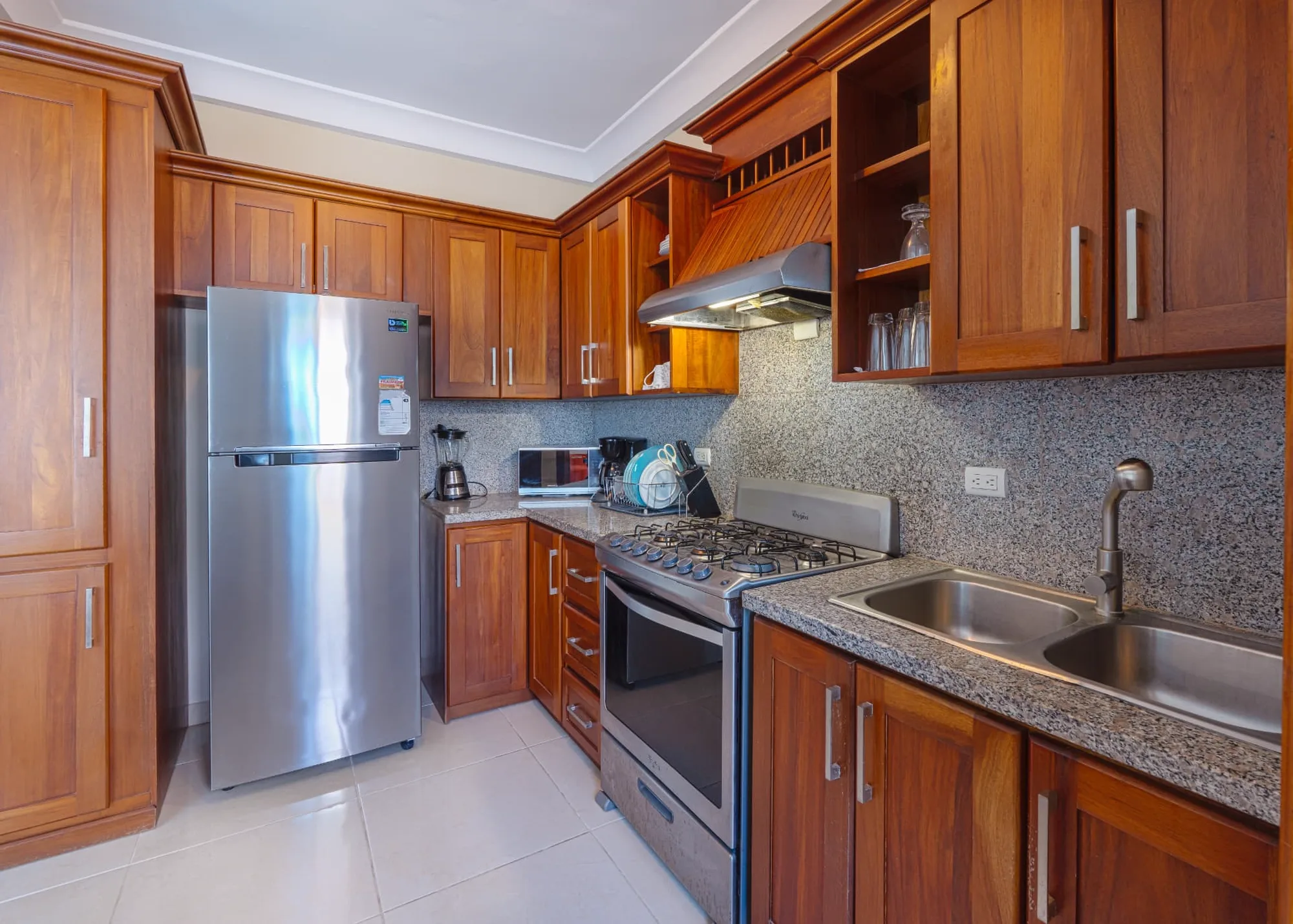 Mahogany kitchen at Eden with granite counters, stainless range, extractor hood and glazed upper cabinets
