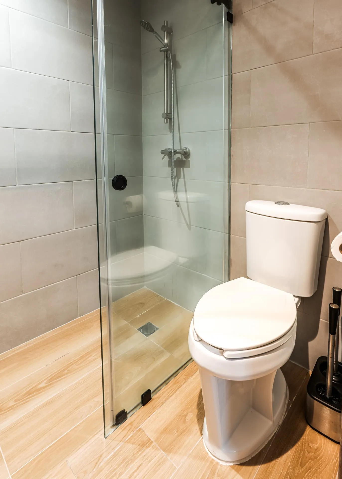 Bathroom with frameless glass shower, rain and handheld fittings and stone-look tiling