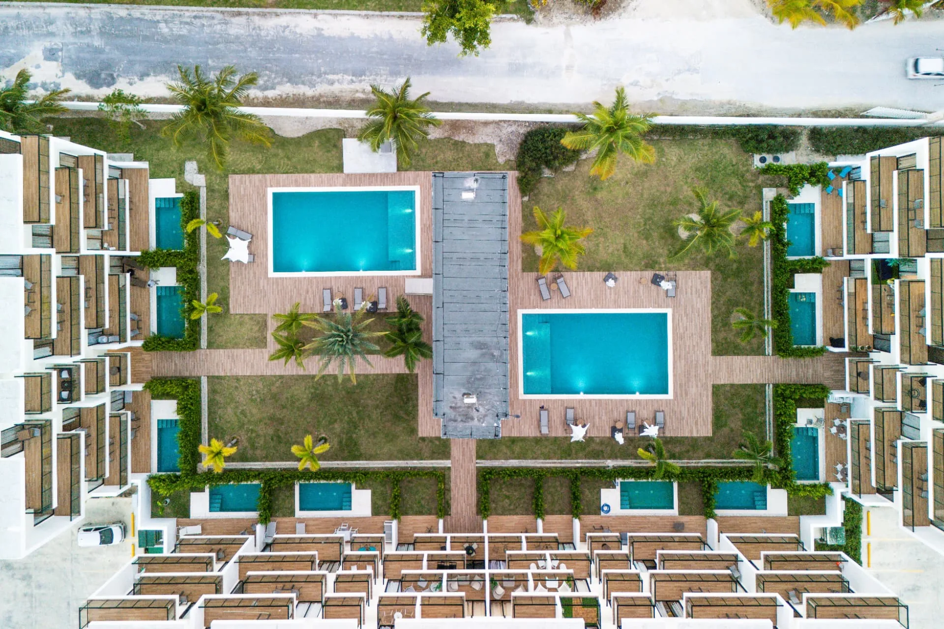 Overhead drone view of the two courtyard pools, timber decks, plunge pools and palm gardens