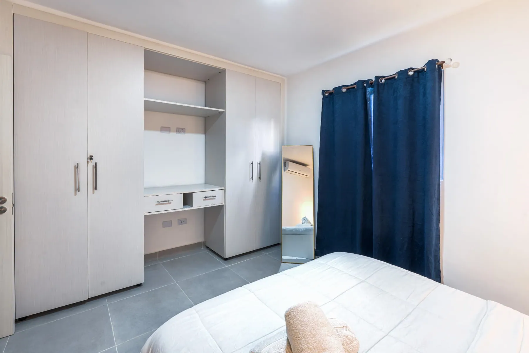 Primary bedroom fitted wardrobes with open shelving, vanity drawers and full-length mirror