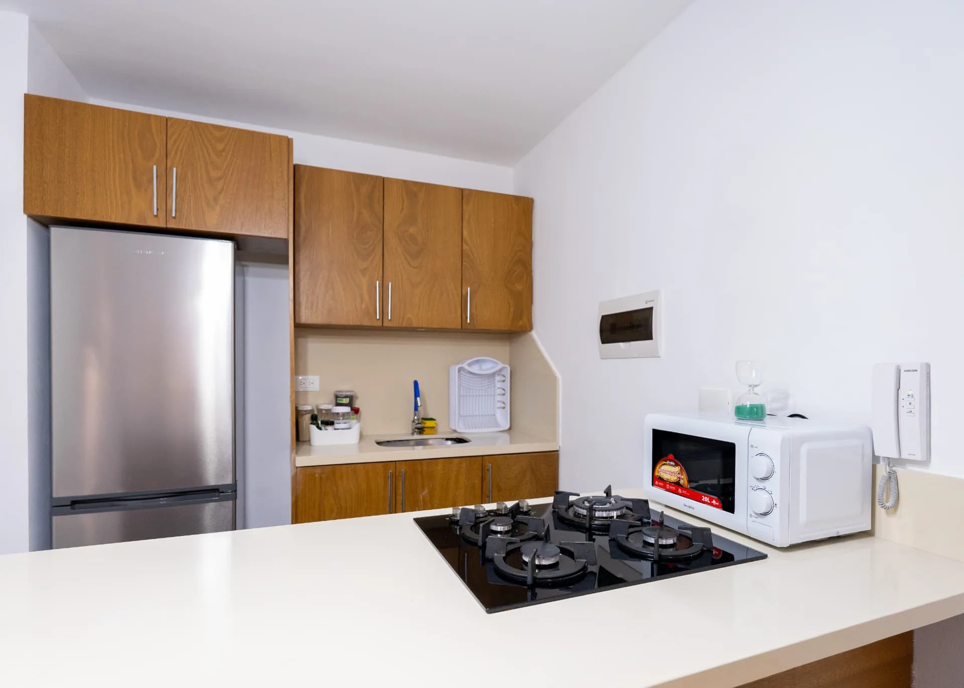 Compact apartment kitchen with timber cabinetry, breakfast bar and gas cooktop