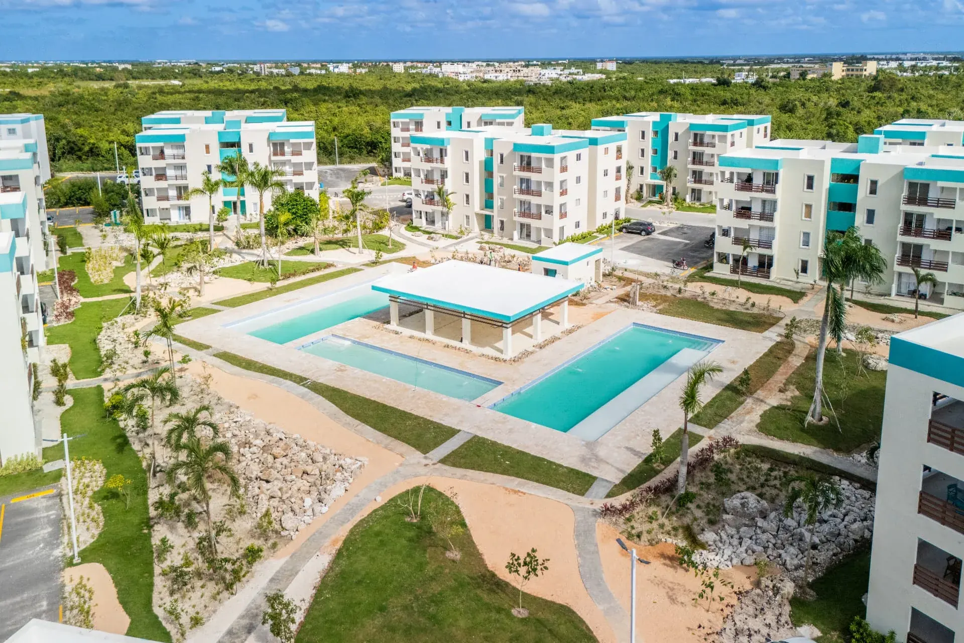 Aerial view of a condominium community with twin swimming pools and shade pavilion