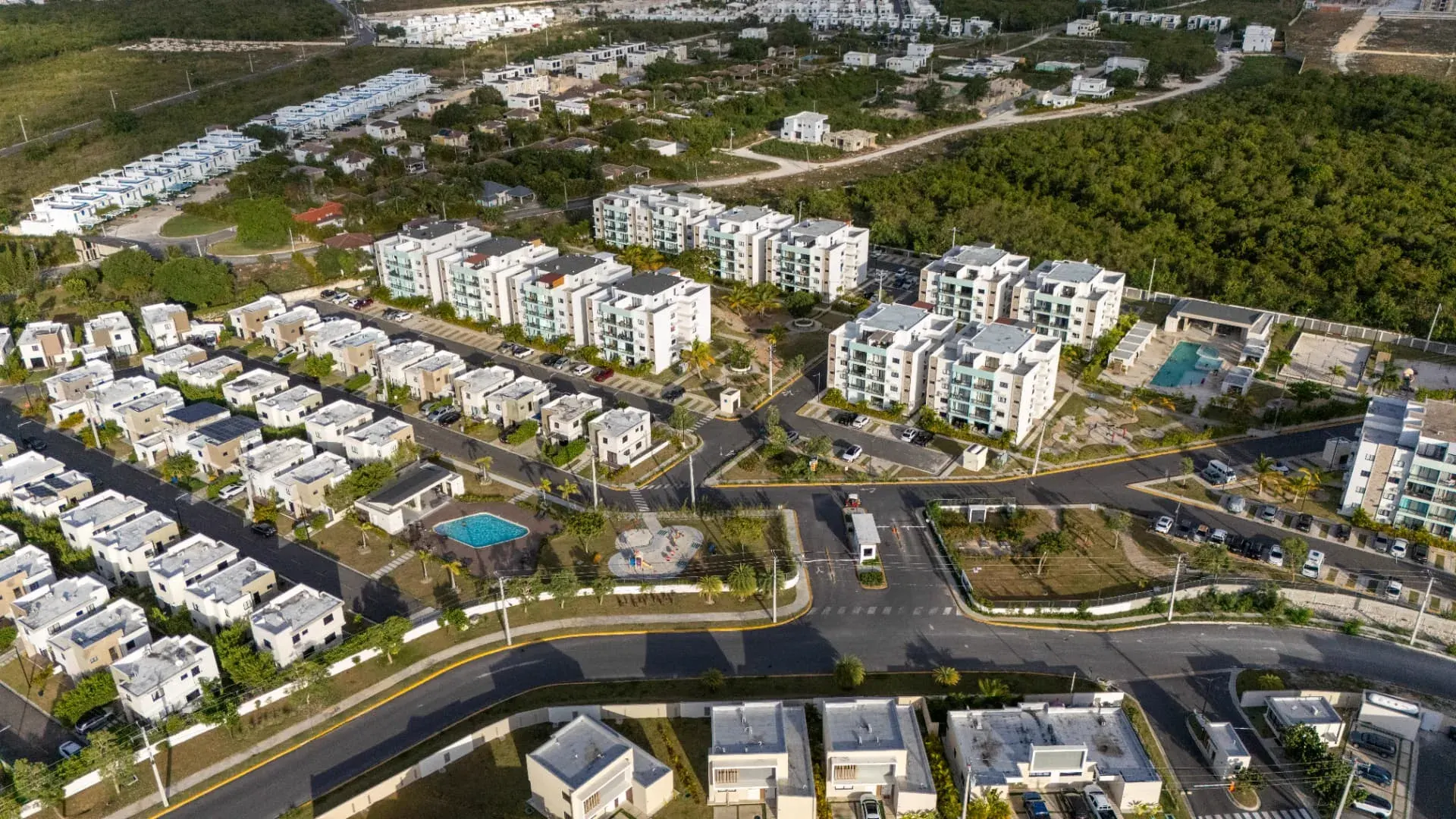 Aerial drone view of the Epic Sun gated community showing apartment blocks, villas, pools and landscaped streets