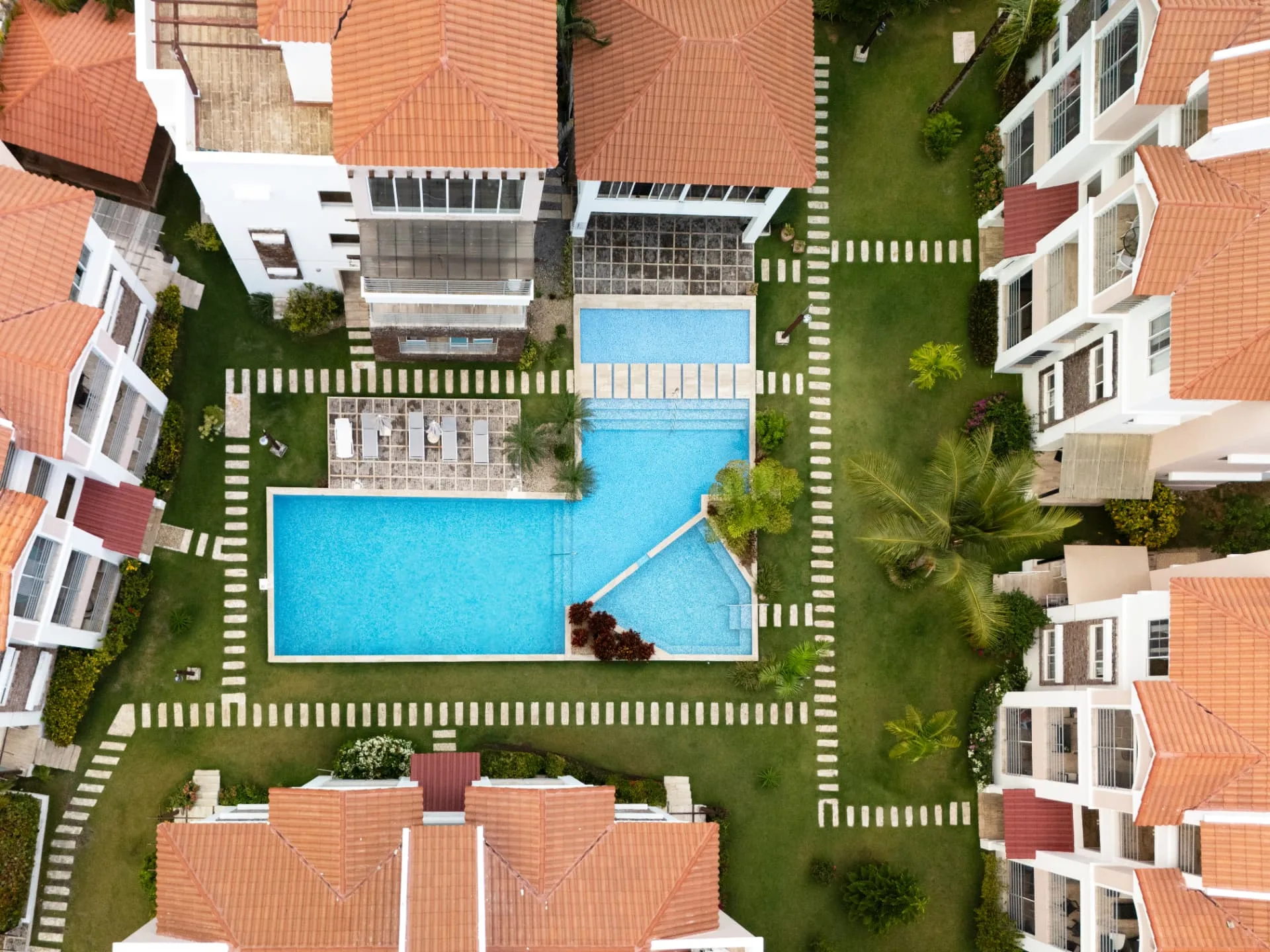 Overhead aerial of the CorteSea community showing the twin pools, sun loungers, lawns and terracotta roofs