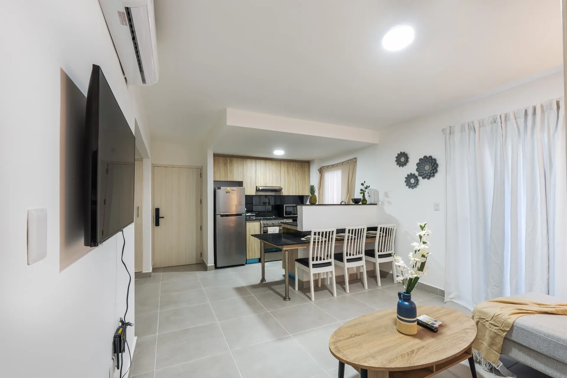 Furnished condominium living area with mounted television, timber kitchen and granite dining bar