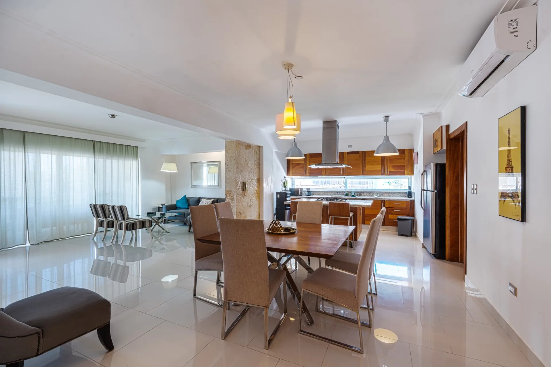 Condominium dining table for six with pendant lighting and a hardwood kitchen with island cooktop