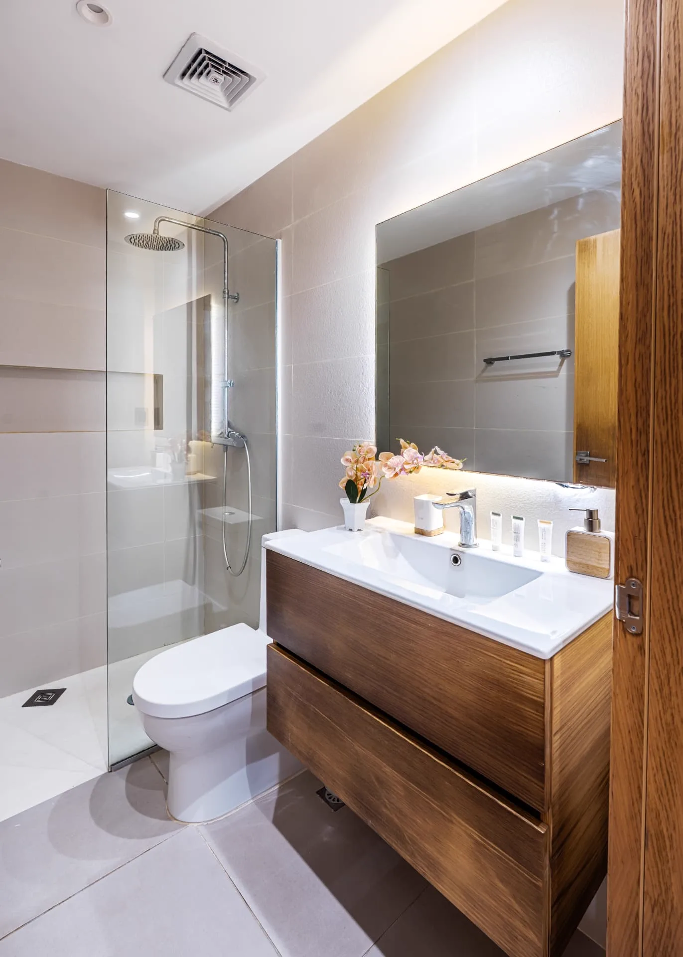 Bathroom with walk-in glass shower, floating timber vanity and backlit mirror