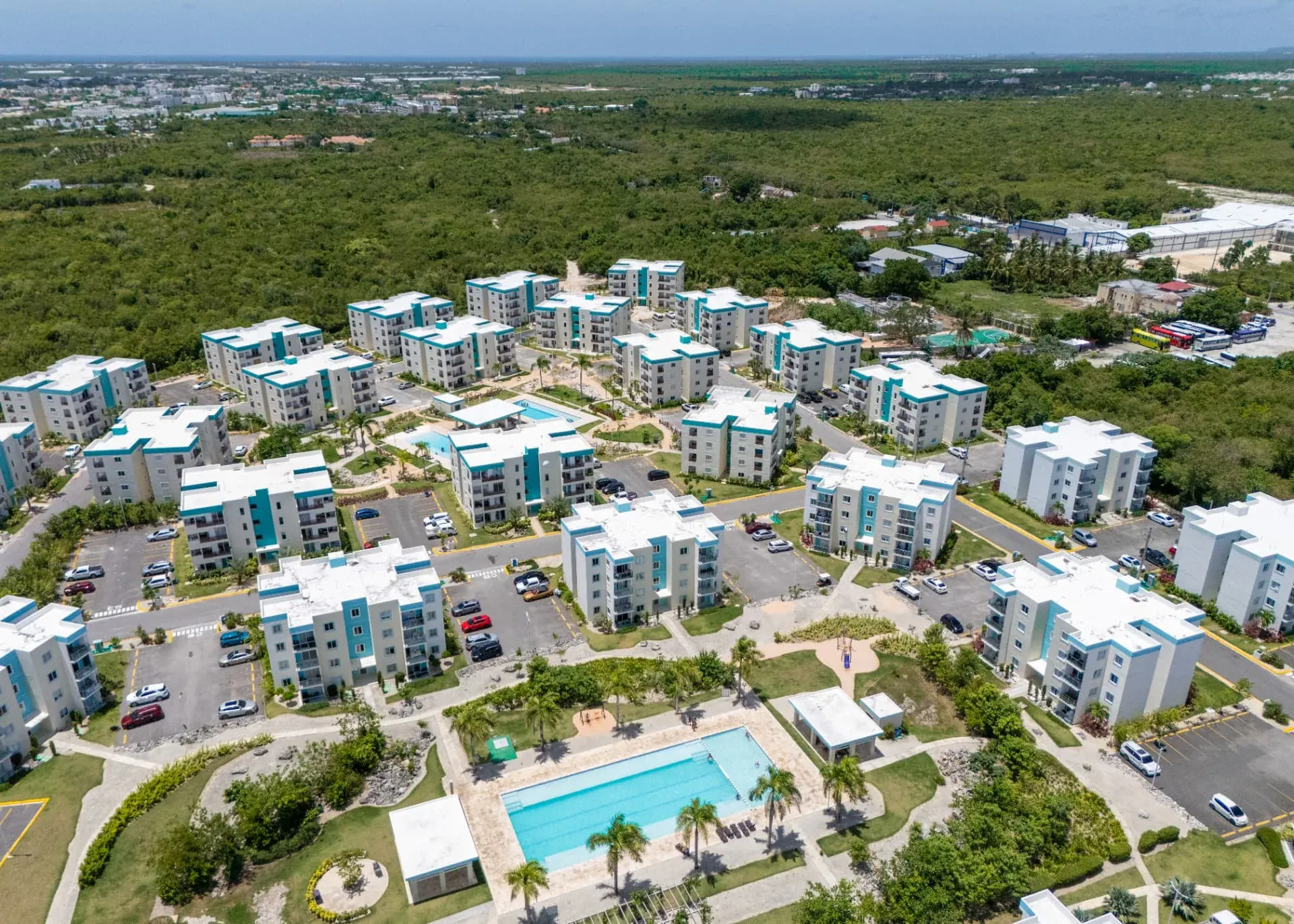 High aerial view of the full condominium community with parking, gardens and the lap pool