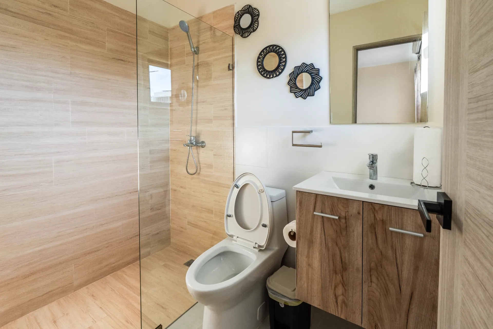 Guest bathroom with light timber-look tiled shower, mahogany vanity and decorative round mirrors