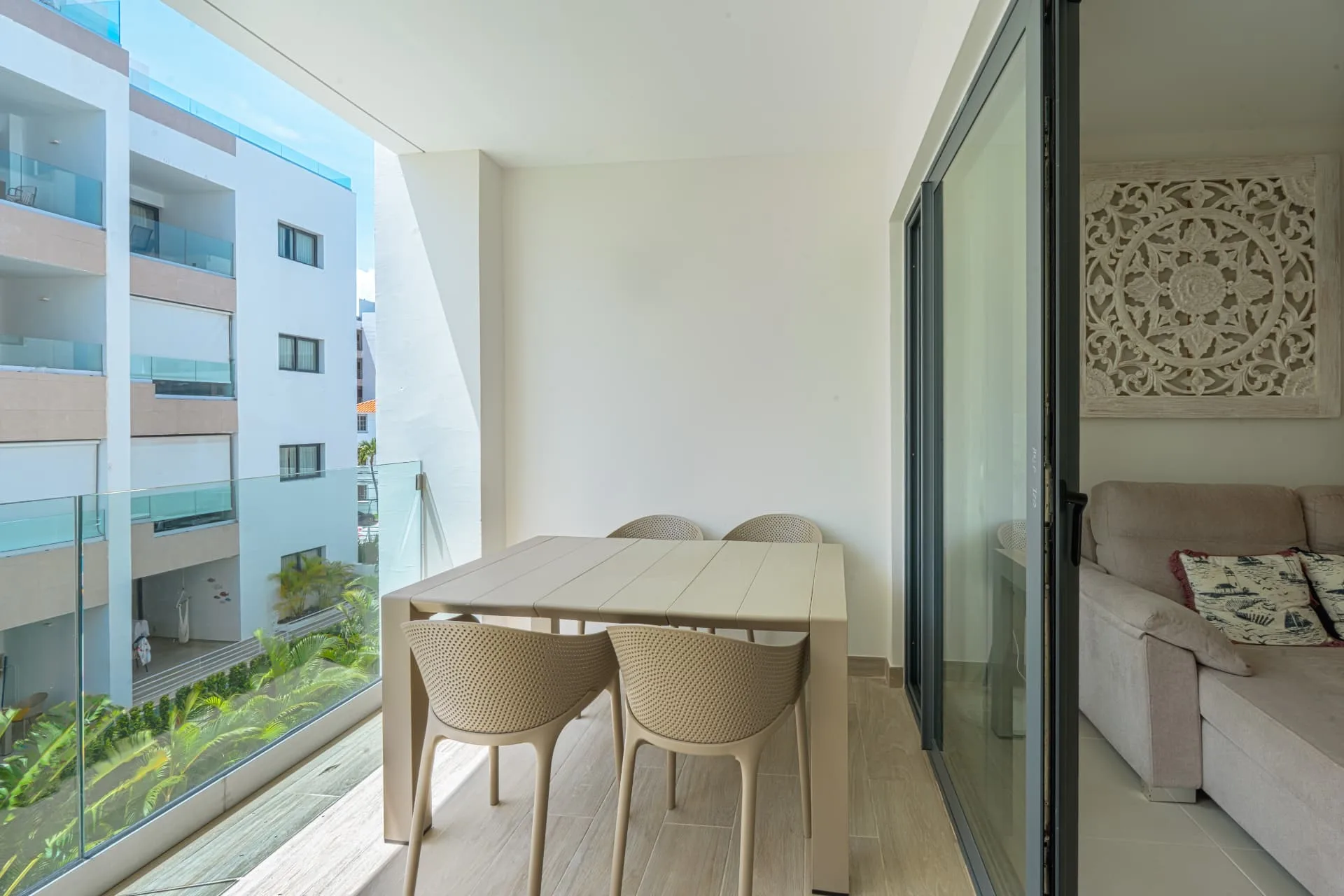 Private balcony with outdoor dining table and chairs, glass railing and views over the courtyard gardens